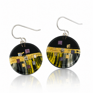 A pair of round disc drop earrings with a black background, featuring a horizontal gold metallic band and small scattered gold, silver, and purple square accents. The earrings are suspended from silver fishhook wires and are shown on a reflective white surface.