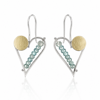 A pair of silver and gold dangle earrings with a heart-shaped wire frame, a textured round gold disc, and a line of faceted light blue beads, shown on a white background with a soft reflection.